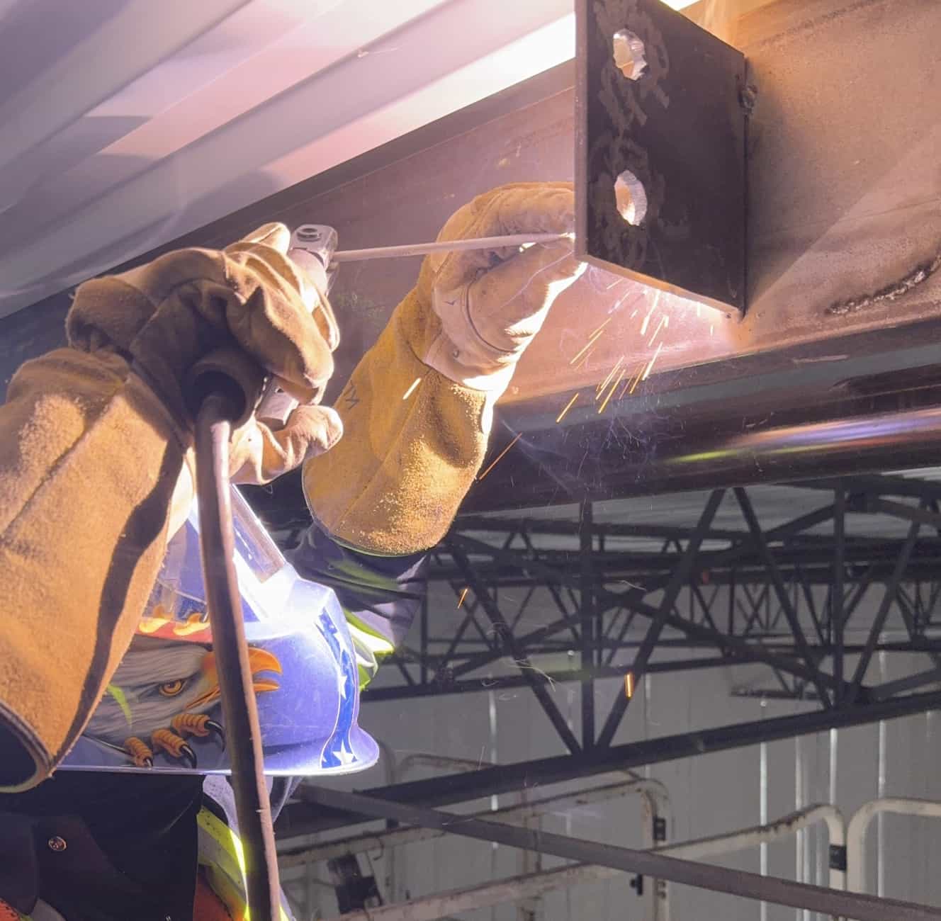 Stick welding a connection bracket onto a structural beam. — Tampa Bay, FL